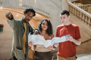 concentrated young multiethnic friends with map in railway station