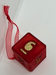 red D6 with silver glitter numbers and silver ribbon