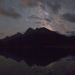 mountains and a starlit sky reflected in water